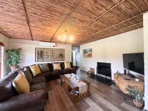 ein Wohnzimmer mit Sofa und Fernseher in der Unterkunft Cottage K'Gari in Franschhoek