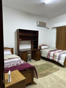 een kamer met 2 bedden en een bureau. bij 3 Bedroom Family Apartment in Amman in Amman