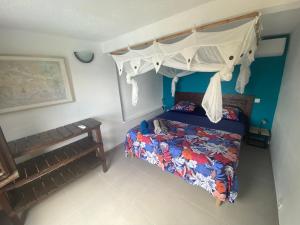 a bedroom with a bed with a canopy at Vue imprenable sur la mer des Caraïbes in Les Anses-dʼArlets