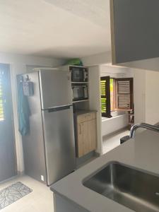 a kitchen with a stainless steel refrigerator and a sink at Vue imprenable sur la mer des Caraïbes in Les Anses-dʼArlets