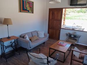 una sala de estar con un sofá y una mesa en Cabañas La Nochera, en Tilcara