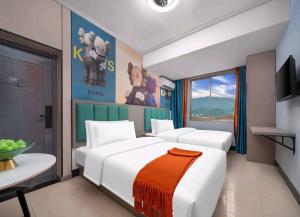 a bedroom with a large white bed with an orange blanket at Jiaming Hotel in Yingwanzhen