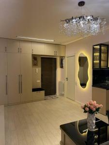 una gran cocina con armarios blancos y un jarrón de flores en Magic Garden, en Tiflis