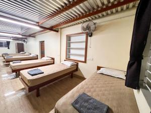 a room with four beds and a window at Shri Amman Residency in Dhārāpuram