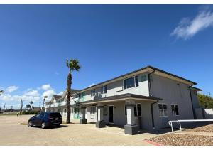 a car parked in front of a building with a palm tree at Conn Brown Harbour Inn Aransas Pass Corpus Christi in Aransas Pass
