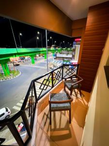 a balcony with two chairs and a view of a parking lot at Shri Amman Residency in Dhārāpuram