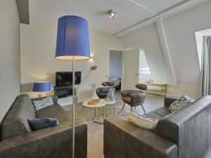 a living room with two couches and a blue lamp at SeaLuxe Suite 27i in Colijnsplaat