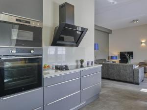 a kitchen with stainless steel appliances and a living room at SeaLuxe Suite 27i in Colijnsplaat