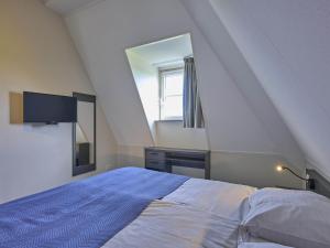 a bedroom with a large bed and a mirror at SeaLuxe Suite 27i in Colijnsplaat