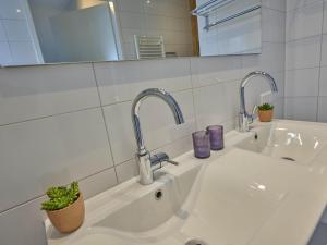 a bathroom sink with two faucets and a mirror at SeaLuxe Suite 27i in Colijnsplaat +29 photos