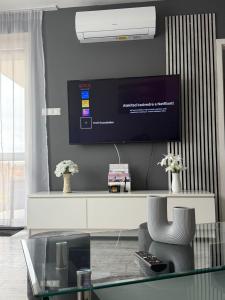 a living room with a tv and a glass table at HIGHWAY Apartman in Győr