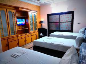 イスラマバードにあるFrank-inn Guest House Islamabadのベッド2台とテレビがあるホテルの部屋