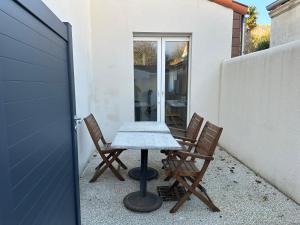 a table and two chairs on a patio at Chez Camille & Emma - Loft Climatisé in Rochefort