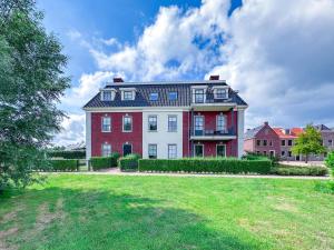 a large red and white house with a yard at Sauna Zee 27H in Colijnsplaat