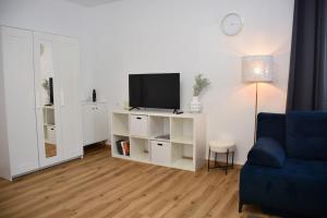 - un salon avec une télévision et un canapé bleu dans l'établissement Studio apartment near center, à Klagenfurt am Wörthersee