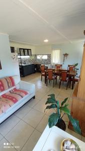ein Wohnzimmer mit einer Couch und einem Tisch und Stühlen in der Unterkunft Lolamora in Balneario Buenos Aires