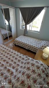 ein Schlafzimmer mit zwei Betten und einem Fenster in der Unterkunft Lolamora in Balneario Buenos Aires