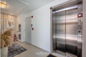 a hallway with a metal elevator in a building at Aptos em prédio à 650 m da Meia Praia - RGOs in Meia Praia