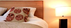 Dormitorio con cama con almohada y lámpara en The Douglas Hotel, en Langholm