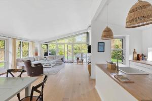 een keuken en een woonkamer met witte muren en ramen bij 823-Tisvildeleje-Vibevaenget-13-A in Tisvilde