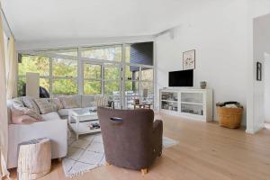 een woonkamer met een bank en een tv bij 823-Tisvildeleje-Vibevaenget-13-A in Tisvilde