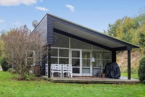 een afgeschermde veranda van een huis met twee witte stoelen bij 823-Tisvildeleje-Vibevaenget-13-A in Tisvilde