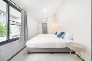 a white bedroom with a bed and a window at The Mellow at Ekkamai in Bangkok +59 photos