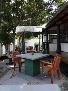 a table and chairs under a pavilion next to the water at Jasmine Chill Cafe & Guest House in Chilaw