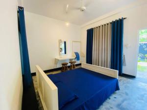 a bedroom with a blue bed in a room at Jasmine Chill Cafe & Guest House in Chilaw