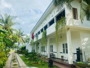 a building with a courtyard with palm trees at Jasmine Chill Cafe & Guest House in Chilaw