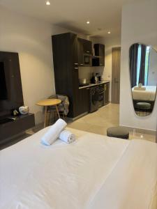 a bedroom with a white bed and a kitchen at Bloom Styled Studio at The Lennox in Accra