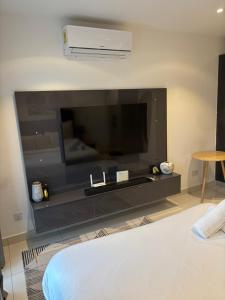 a living room with a large flat screen tv at Bloom Styled Studio at The Lennox in Accra