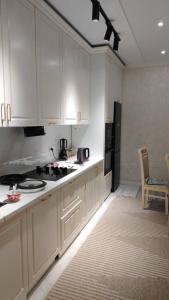 een keuken met witte kasten en een fornuis bij Voyage in Karakol