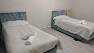 twee bedden in een kamer met witte handdoeken erop bij Voyage in Karakol +12 foto's