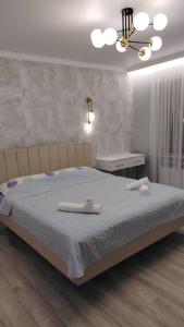 een slaapkamer met een groot bed met twee handdoeken erop bij Voyage in Karakol