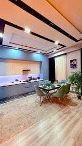 a dining room with a table and chairs and a kitchen at Gardens resident Tashkent city in Tashkent