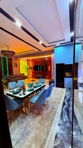 a living room with a table and blue chairs at Gardens resident Tashkent city in Tashkent