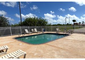 a small swimming pool with chairs and a fence at Conn Brown Harbour Inn Aransas Pass Corpus Christi in Aransas Pass