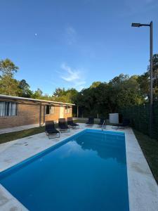 Una piscina azul con sillas y una valla. en Complejo San San, en San Luis