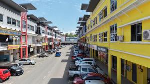 a row of cars parked in a parking lot next to buildings at Hotel Benoni in Papar