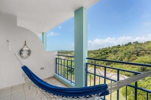 a room with a hammock on a balcony with a view at Santorini Coastal Vibe Apartment in Costa Brava Ceiba in Santa Maria
