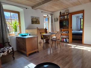ein Wohnzimmer mit einem Schreibtisch, einem Tisch und Stühlen in der Unterkunft König Ludwig' das märchenhafte Appartement in Oberammergau