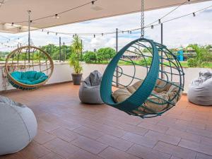 two hanging hammocks on a patio with a view at Golden Tower Maurilio Biagi by Fênix Hotéis in Ribeirão Preto