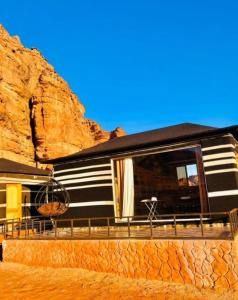 a black and white rv parked next to a cliff at RUM DREAM BUBBLES lUXURY CAMP in Wadi Rum