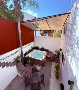 a patio with a hot tub and a palm tree at Sabalo's Hausen in Mazatlán