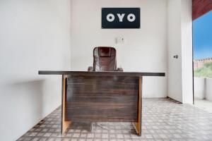 a desk in a room with a sign on the wall at SPOT ON HM HOTEL in Mundarwa