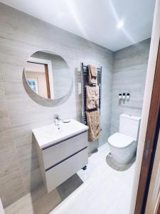 ein Badezimmer mit Waschbecken, Toilette und Spiegel in der Unterkunft Little Dunton Lodges 2 in Brentwood