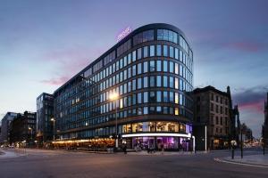 a tall glass building with a sign on top of it at YOTEL Glasgow in Glasgow