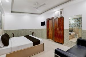 a hotel room with a bed and a chair at Hotel O Akki Residency in Indirapuram