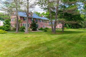 a large pink house with trees in the yard at TuckAway Suites at East Branch in Intervale